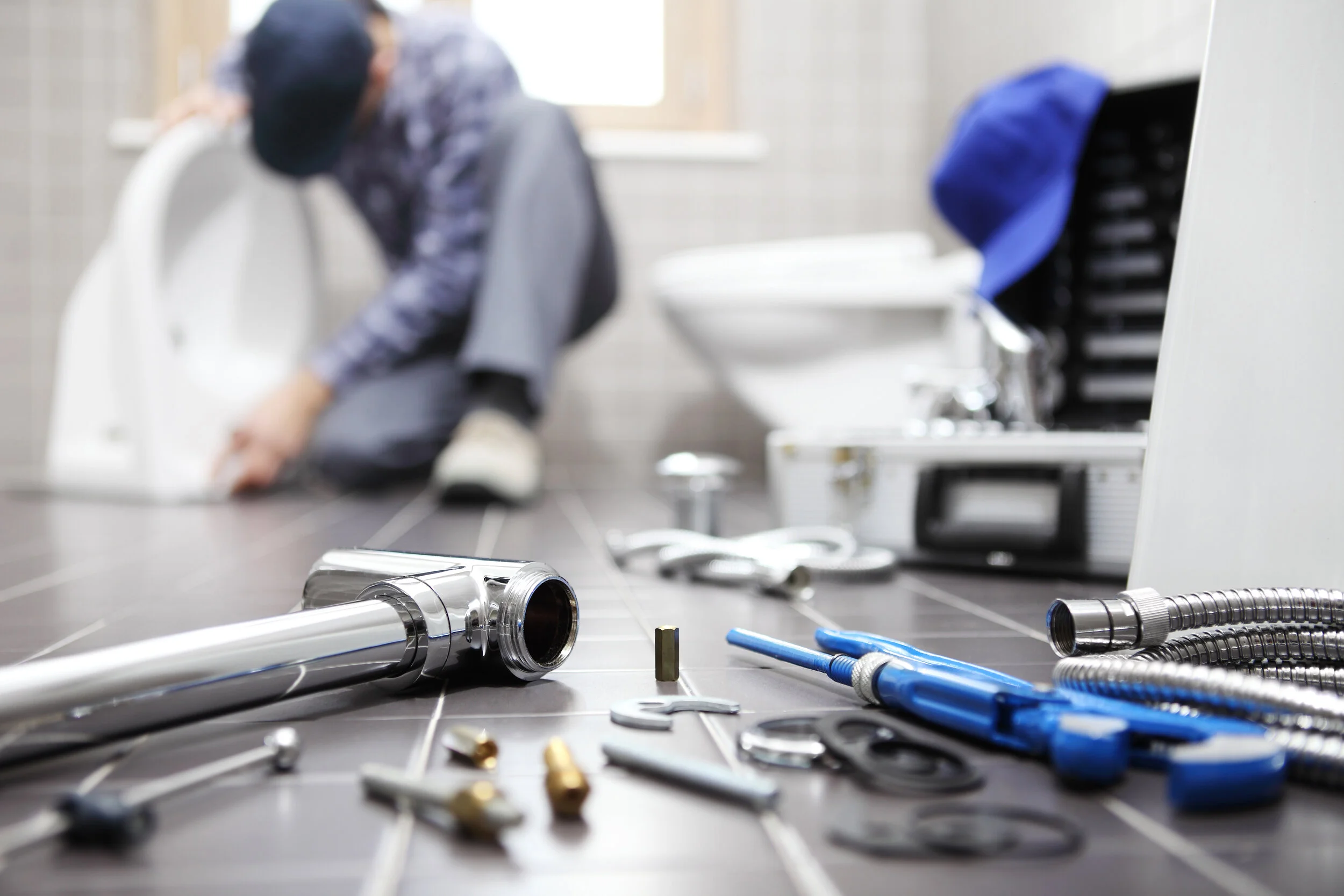 Plumber servicing residential hot and cold water connections
