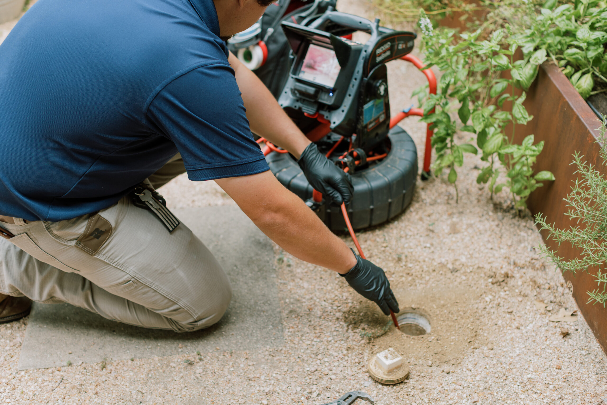 Plumber clearing a residential drain and checking pipe connections
