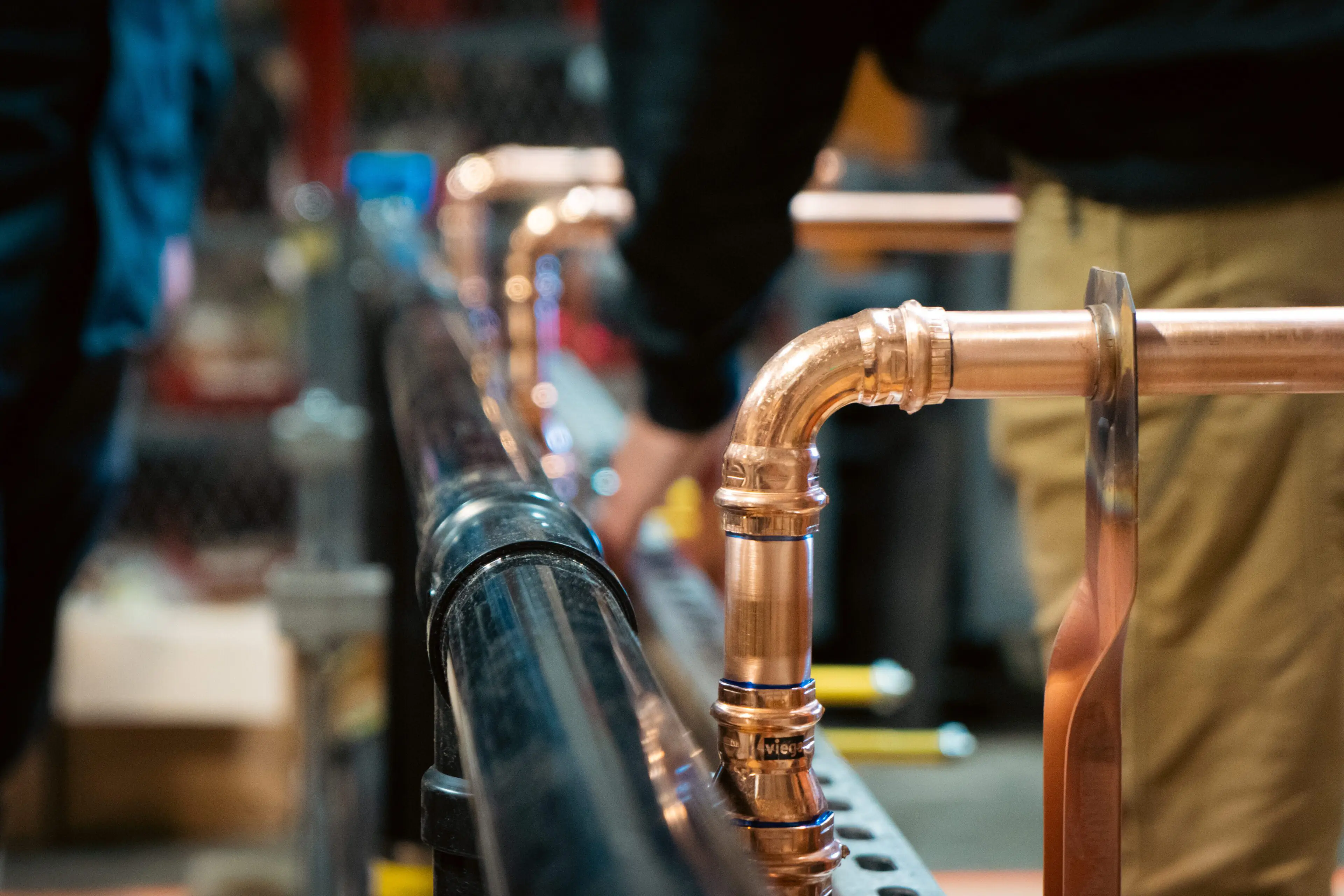 Professional plumber inspecting pipes and preparing tools for a repair